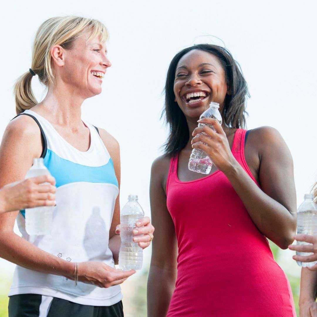 two women laughing holding water bottles